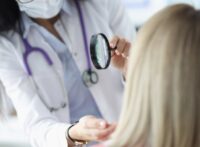 Dermatologist examining woman's face